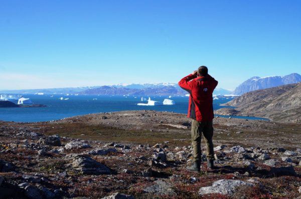 Using binoculars to scan the shore for polar bears in Ittoqqortoormiit, Greenland.